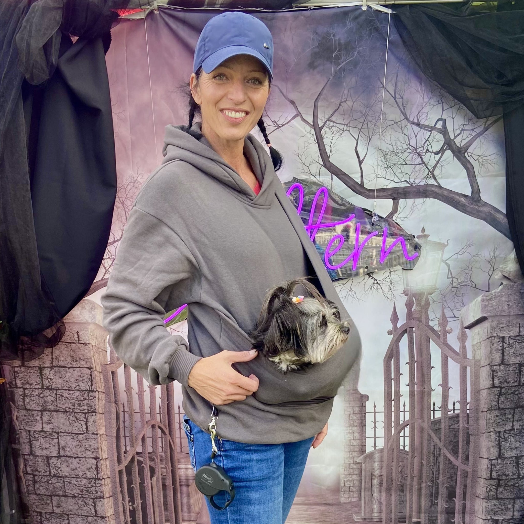 Woman wearing a dog hoodie sling with a dog inside the pocket